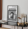 A Black and white architectural photograph print of Washington Square Arch in Greenwich Village, New York City, with people playing soccer in the foreground.