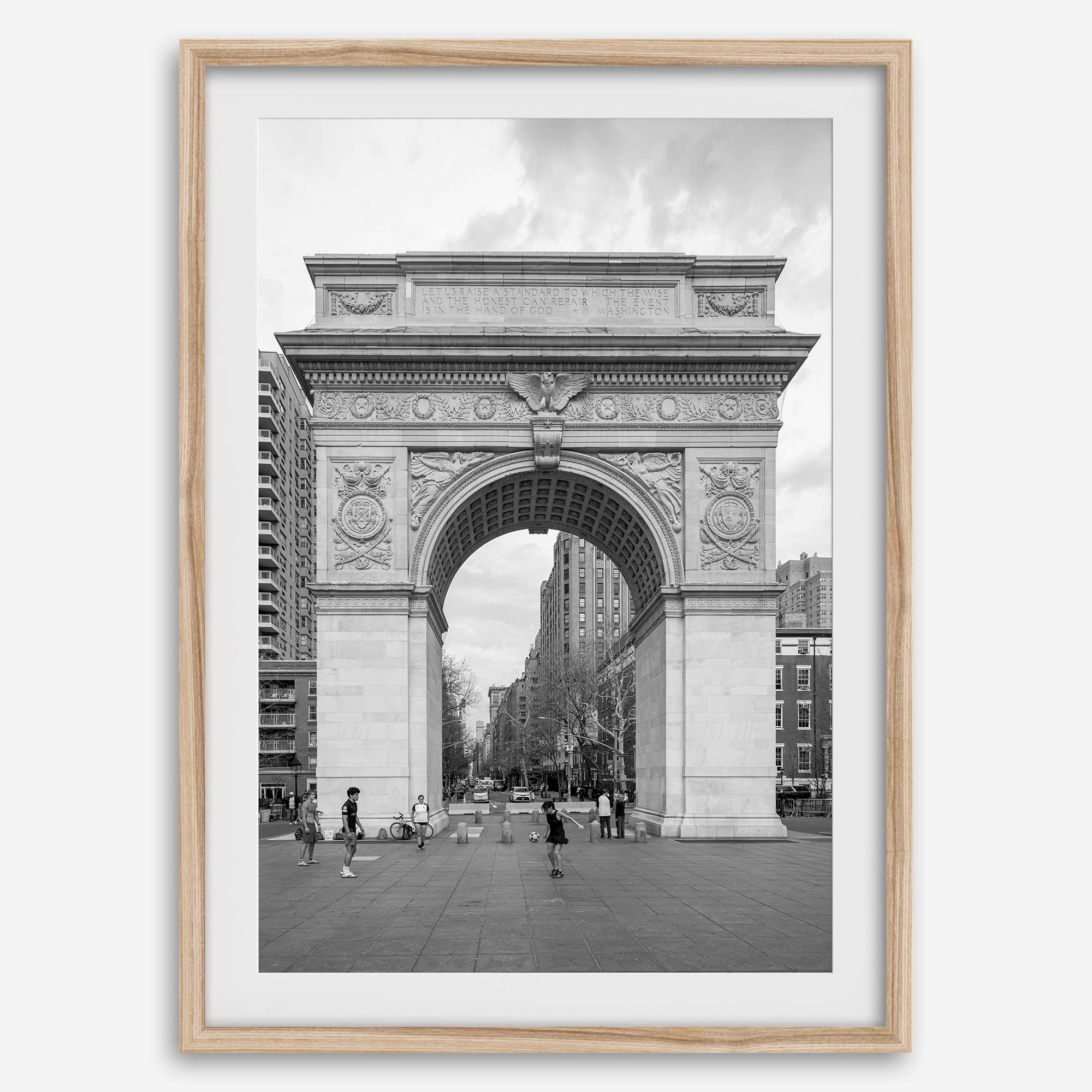 A Black and white architectural photograph print of Washington Square Arch in Greenwich Village, New York City, with people playing soccer in the foreground.