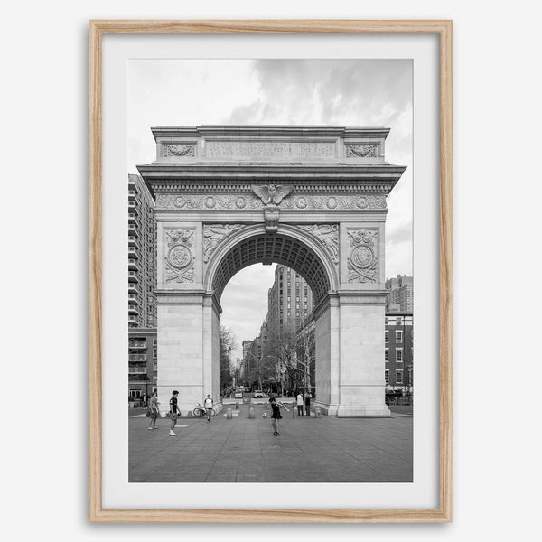 A Black and white architectural photograph print of Washington Square Arch in Greenwich Village, New York City, with people playing soccer in the foreground.
