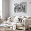 Black and white zebra wall art showing a herd of zebras with overlapping striped patterns, presented in a black frame with a white mat.