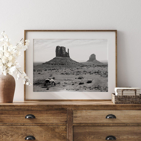 Capture the spirit of the Wild West with this black and white fine art photo print. A majestic horse stands in front of the iconic Monument Valley rocks. A timeless desert wall art that transports you to the rugged beauty of the American Southwest.