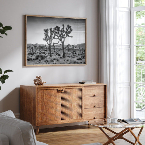 A fine art black and white framed or unframed photography print showcasing two Joshua trees seemingly holding hands in the sunset. This desert wall art will be a great addition to your home or office decor.