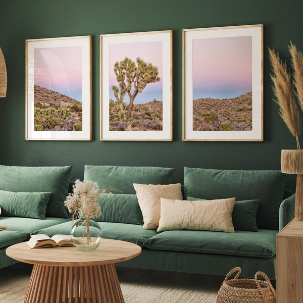 A wall art set of 3 framed or unframed Joshua Tree National Park prints. This desert wall art showcases a stunning Joshua Tree and the desert terrain and plants in a breathtaking Pink sunset filled with Pink and Purple hues. Modern gallery wall set