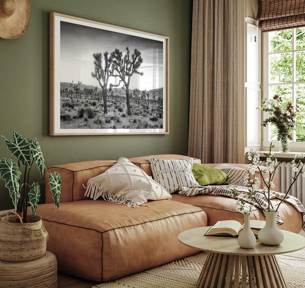 A fine art black and white framed or unframed photography print showcasing two Joshua trees seemingly holding hands in the sunset. This desert wall art will be a great addition to your home or office decor.