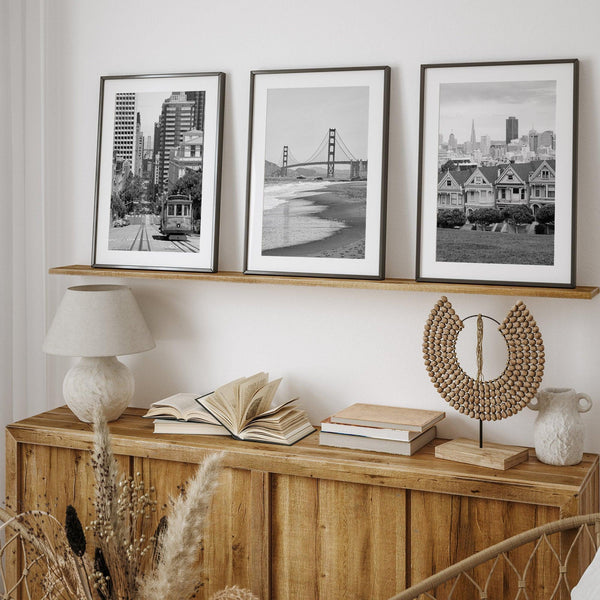 A San Francisco oversized set of 3 framed or unframed wall art. The prints feature a San Francisco cable car overlooking the Bay Bridge, the Golden Gate Bridge from Baker Beach, and the famous Painted Ladies with the San Francisco skyline.