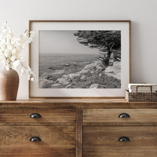 Black and white coastal art featuring Pebble Beach’s rocky shoreline and ocean view.