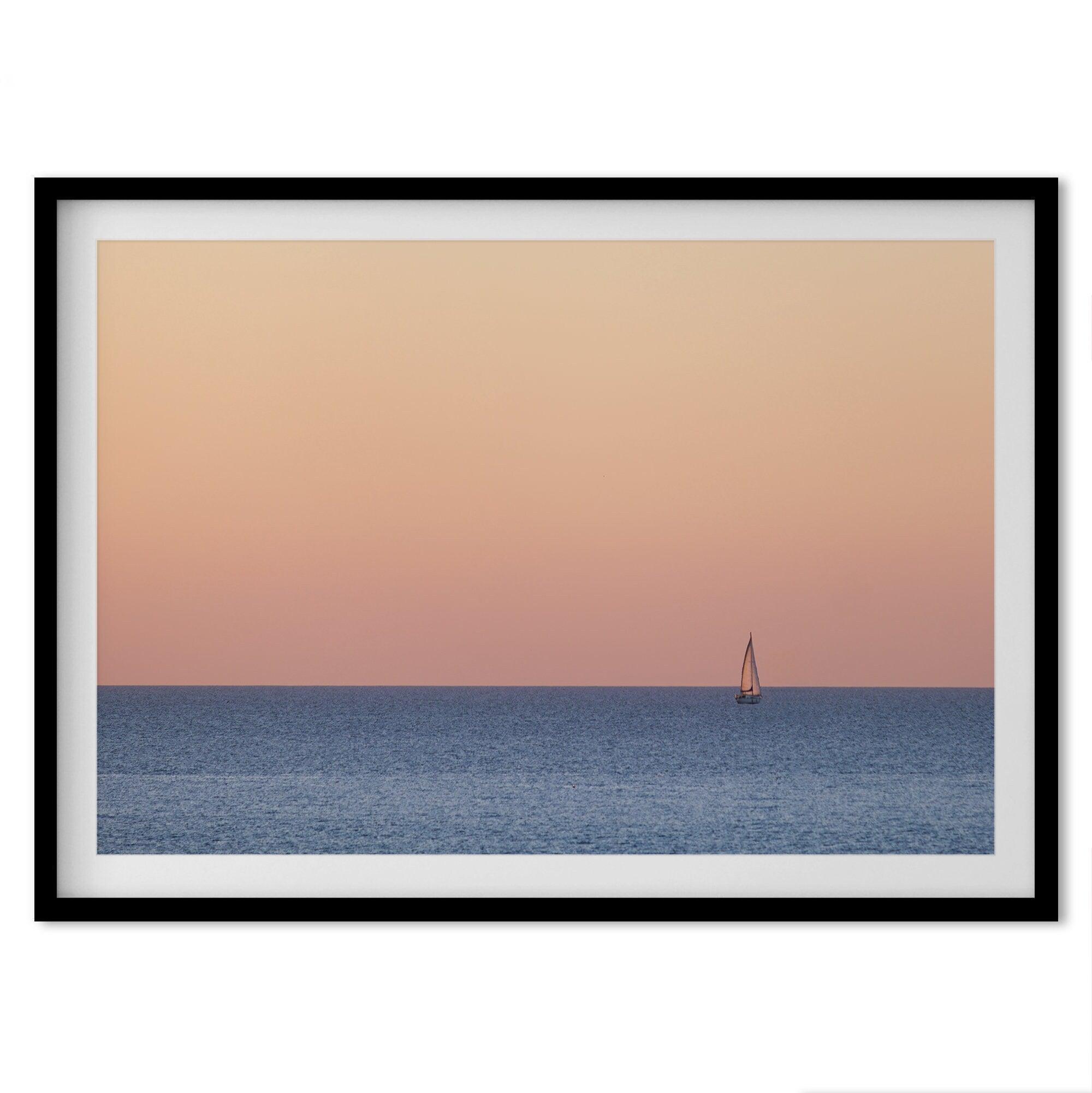 This stunning fine art ocean sunset photography print features a breathtaking scene of a boat against a golden and pink sky at sunset. The warm glow of the sunset and the natural beauty of the ocean and sky combine to create a soothing atmosphere.